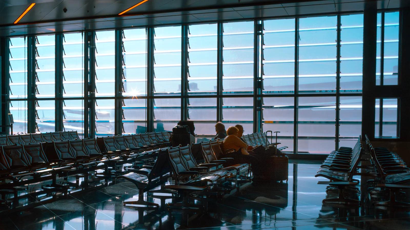 Passengers waiting inside a bright airport terminal