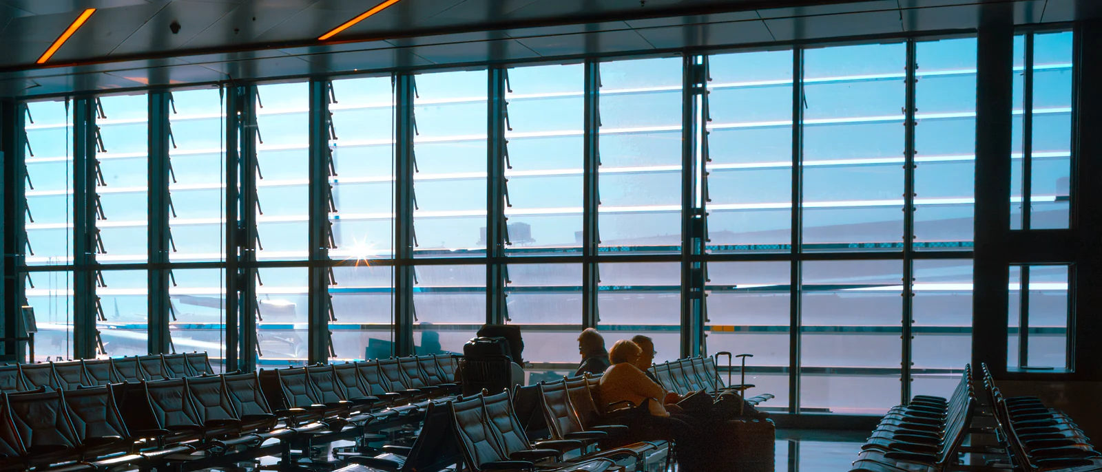 Passengers seated in a bright airport terminal