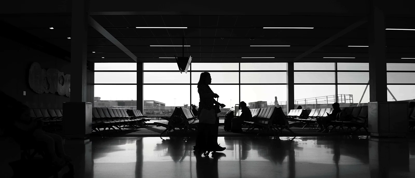 Passenger waiting alone in a darkened airport gate area